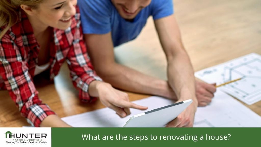 Couple reviewing house renovation plans on tablet